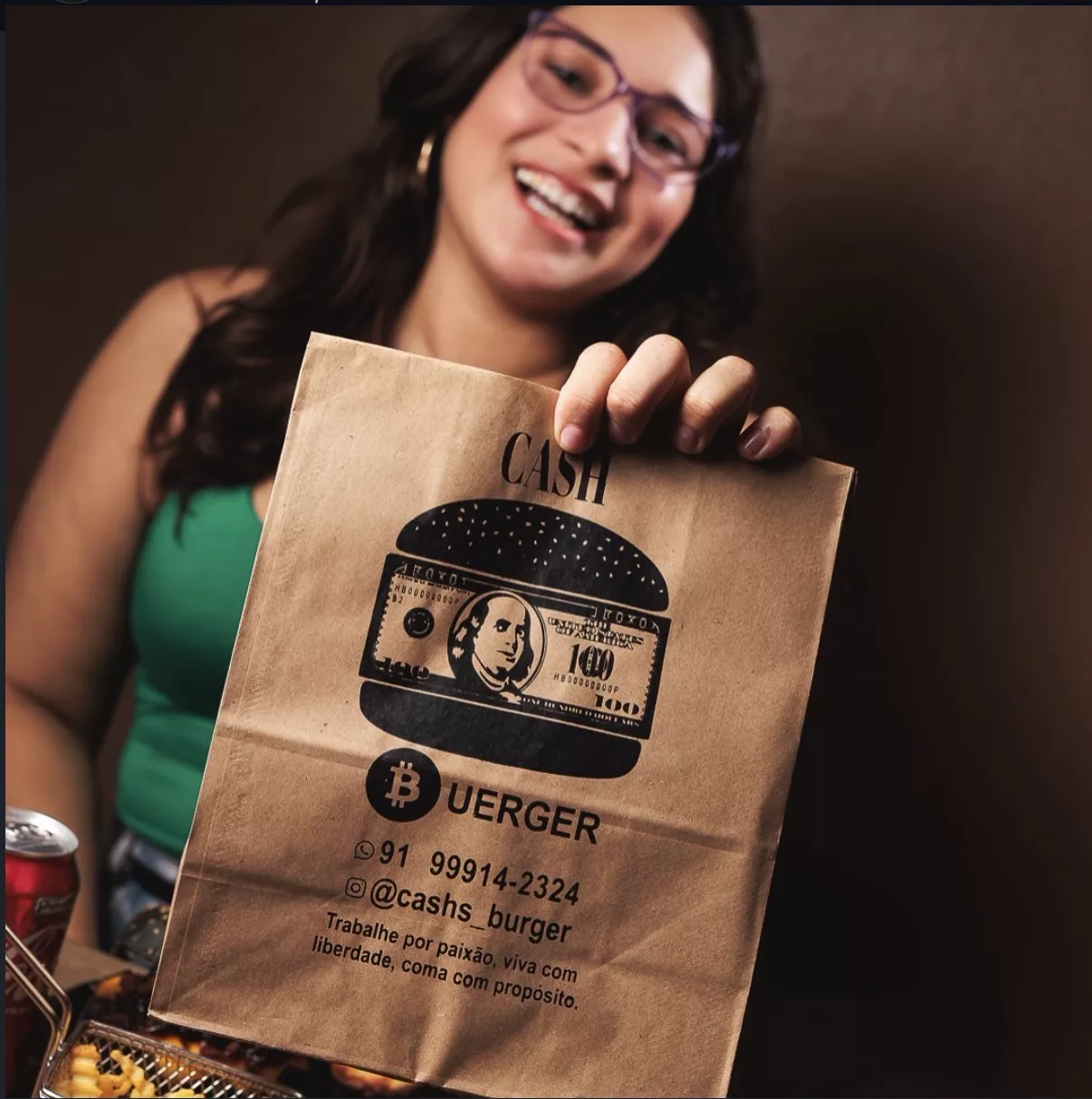 Cliente segurando a sacola kraft da Cash Burger